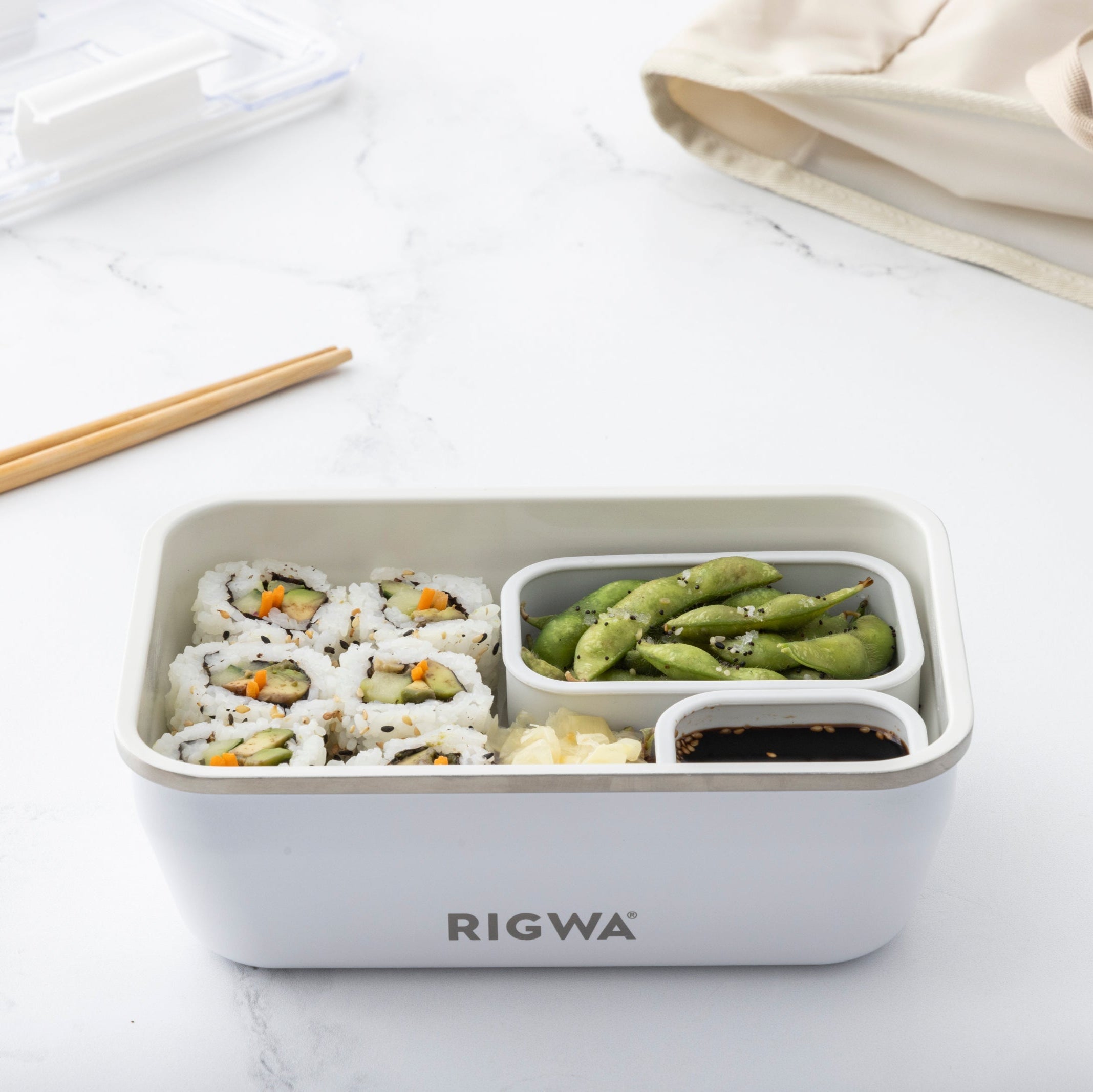 RIGWA bento box with sushi and vegetables on a white surface