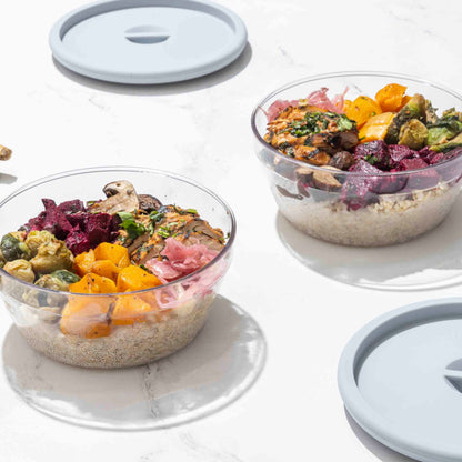 Two Tritan bowls with assorted toppings on a white surface